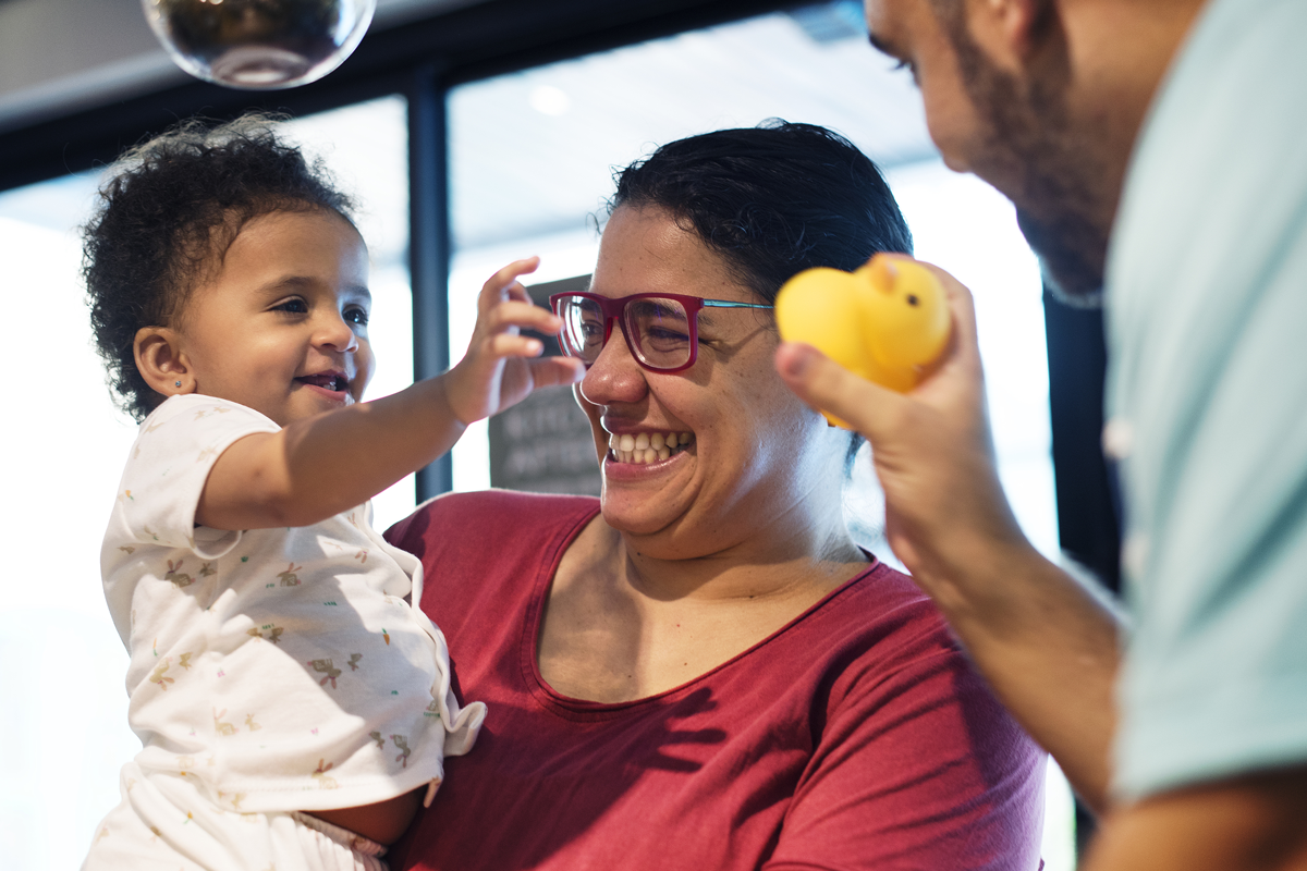 Parents playing with their young daughter, symbolizing family engagement.